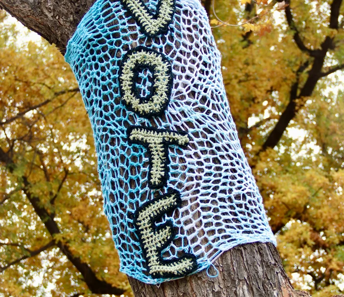 Crocheted Vote sign on tree