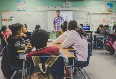 A classroom with children led by a teacher.